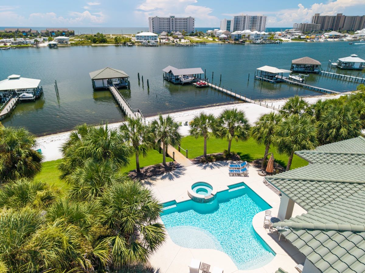 Aerial view of a waterfront home with pool and private boat docks, Ono Island